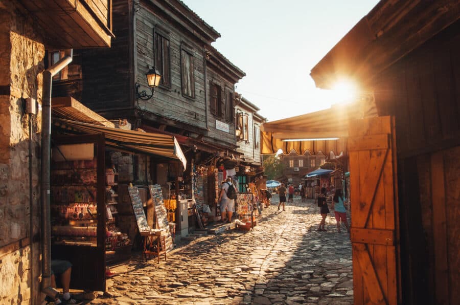 Things to do in Burgas - People walk through streets of ancient nesebar at sunset.