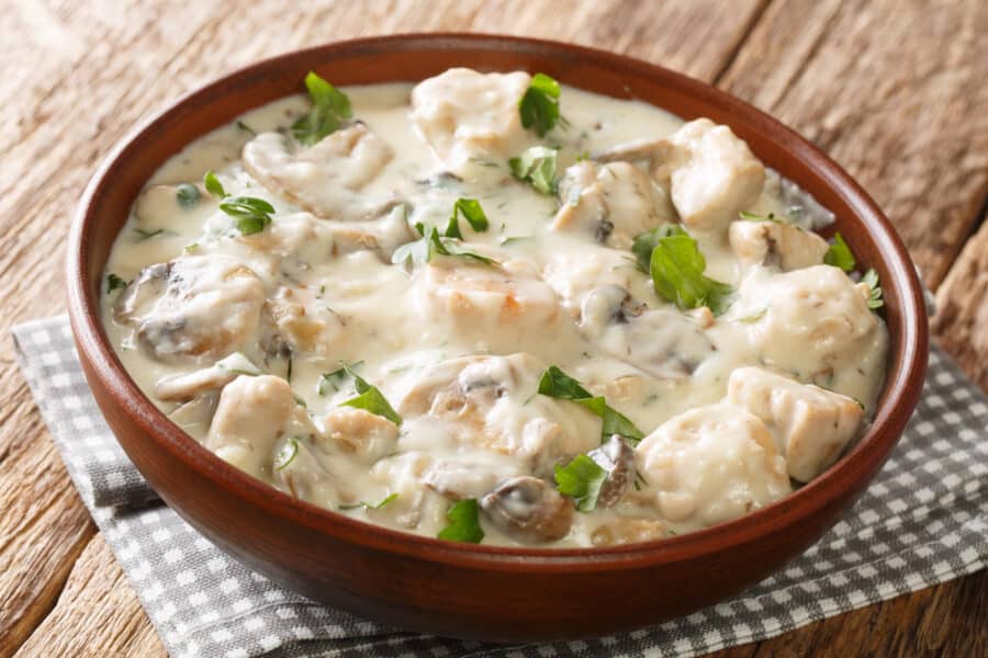 Ciulama chicken fricassee with white creamy sauce roumanian recipe closeup in the plate on the table