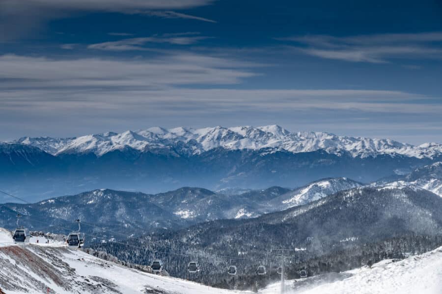 The famous snowed mountain of Parnassos with popular ski resort covered up in snow and unique nature, cable cabins, car parking, Voiotia, Greece