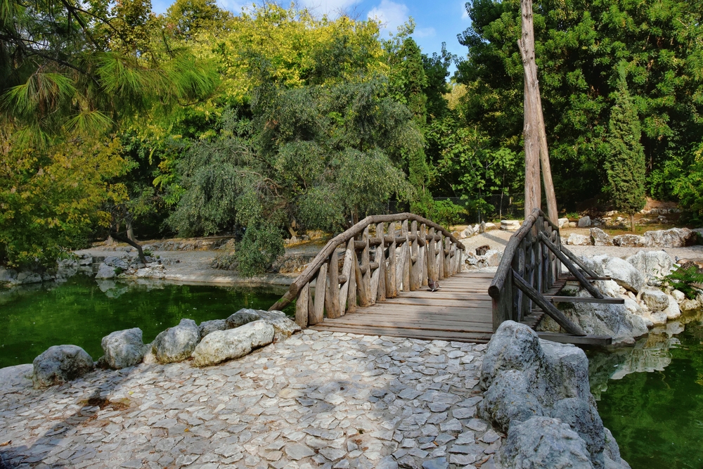 Wooden bridge across the pond in National garden of Athens